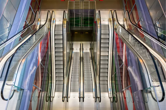 Symmetrische rijen roltrappen met glazen balustrades van bovenaf gezien