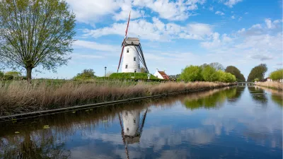 Witte windmolen weerspiegeld in het water, de foto