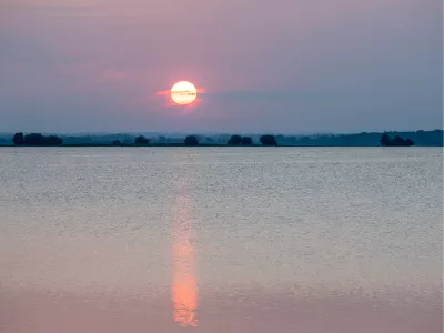 Gloeiende Zon boven het Water, de foto