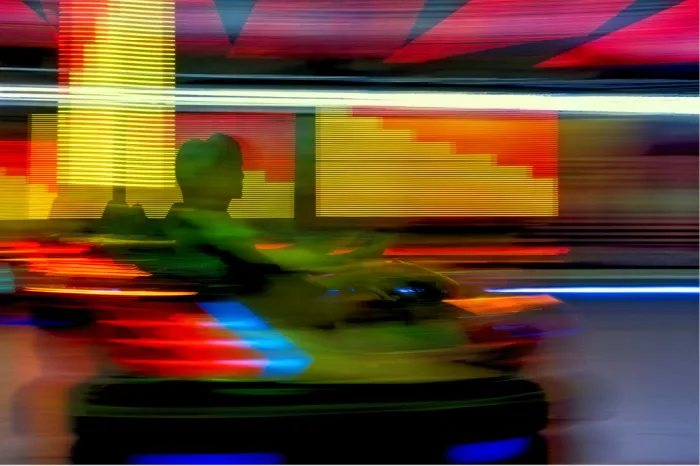 Abstracte en kleurrijke foto van twee mensen in een botsauto op de kermis