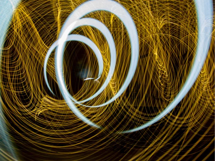 Witblauwe lichtspiraal over een web van goudgele lichtlijnen