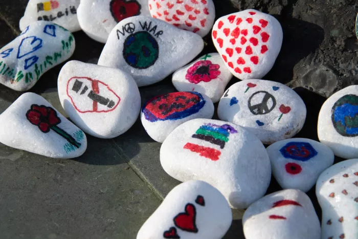 Witte keien beschilderd met vredestekens, hartjes en boodschappen tegen oorlog