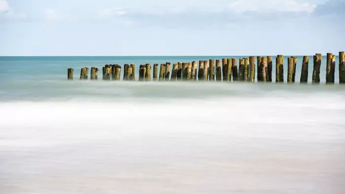 De paalhoofden op het strand langs de Opaalkust lijken op te lossen in de zee, met dank aan de lange sluitertijd.
