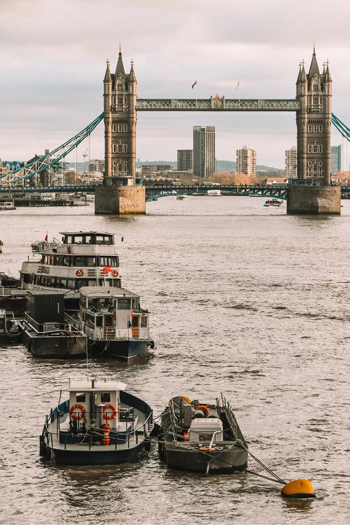 Tower Bridge in Londen over de Theems met afgemeerde boten op de voorgrond
