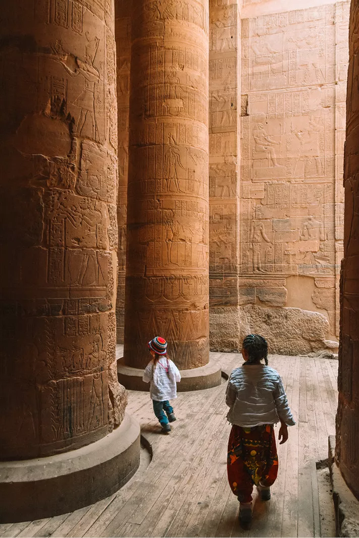 Twee kinderen tussen hoge zuilen met hiërogliefen in een Egyptische tempel