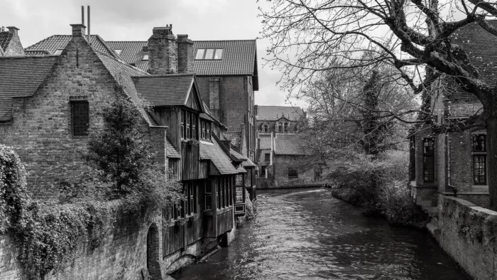 Historische gevels weerspiegelen zich langs een rustig stromende waterweg