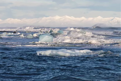 Blue ice adrift before white peaks, de foto