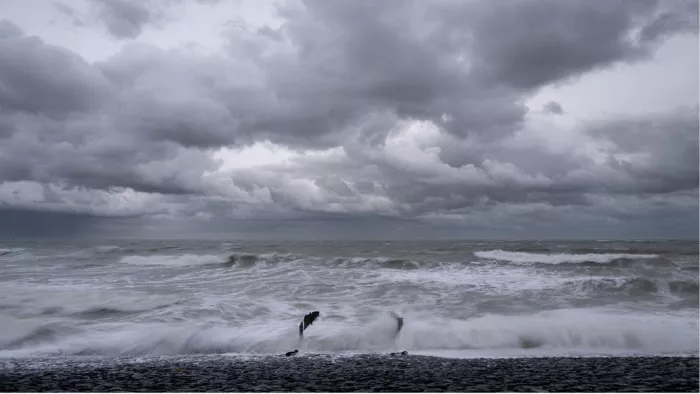 Woelige zee bij storm met paalhoofden in de golven onder donkere wolken