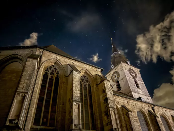 Gotische ramen en klokkentoren van de kerk van Merchtem onder een sterrenhemel