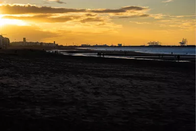 Zonsondergang aan het strand met skyline, de foto