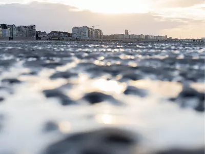 Reflecties op nat zand bij zonsondergang, de foto